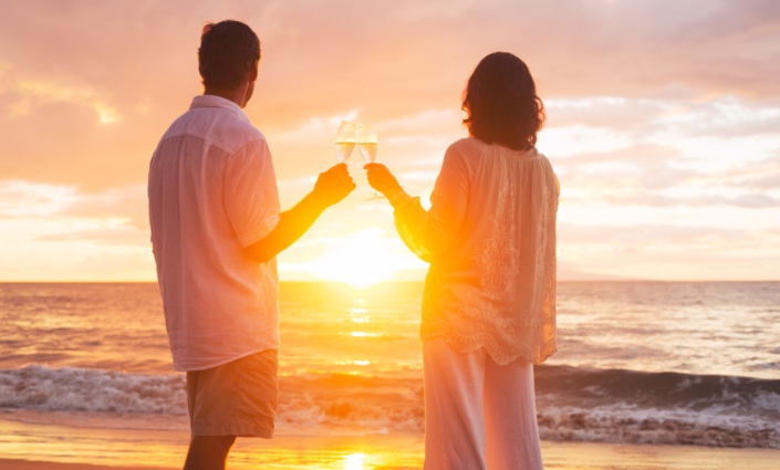 Couple Enjoying Glass of Champene on the Beach at Sunset
